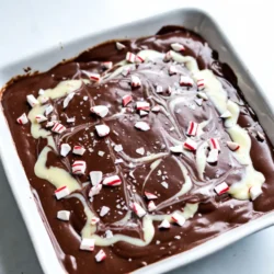 Für mein schnelles Pfefferminz-Fudge benötigst du: - 2 Tassen halbsüße Schokoladenstückchen - 1 Dose (397 g) gesüßte Kondensmilch - 1 Teelöffel Pfefferminzextrakt - 1 Tasse zerdrückte Pfefferminzbonbons oder Zuckerstangen - 1/2 Tasse weiße Schokoladenstückchen (für einen Swirl-Effekt) - Eine Prise Meersalz Diese Zutaten sind einfach zu finden. Die halbsüßen Schokoladenstückchen geben dem Fudge einen tollen Geschmack. Die gesüßte Kondensmilch sorgt für die cremige Textur. Der Pfefferminzextrakt bringt den frischen Geschmack. Die Prise Meersalz ist wichtig. Es hebt den süßen Geschmack der Schokolade hervor. Du kannst auch andere Gewürze hinzufügen, wenn du magst. Zum Beispiel, ein Hauch von Vanille kann eine schöne Note geben. Die zerdrückten Pfefferminzbonbons sorgen für Knusprigkeit und einen tollen Look. Die Nährwerte sind wichtig, wenn du auf die Ernährung achtest. Ein Stück Fudge hat ungefähr: - Kalorien: 150 - Fett: 8 g - Kohlenhydrate: 20 g - Zucker: 15 g - Eiweiß: 2 g Diese Werte können je nach Zutaten variieren. Das Fudge ist süß und reichhaltig, also genieße es in Maßen. Es ist perfekt als kleiner Snack oder zum Teilen mit Freunden. {{ingredient_image_2}} Zuerst bereite die Backform vor. Nimm eine 20x20 cm große Form. Lege sie mit Backpapier aus. Lass genug Papier überhängen. So hebst du das Fudge später leichter heraus. Jetzt geht es ans Schmelzen. Gib die halbsüßen Schokoladenstückchen in einen Topf. Füge die gesüßte Kondensmilch hinzu. Erhitze die Mischung bei niedriger bis mittlerer Hitze. Rühre ständig, bis alles geschmolzen und glatt ist. Nimm den Topf jetzt vom Herd. Füge den Pfefferminzextrakt und eine Prise Meersalz hinzu. Rühre gut um, damit alles gleichmäßig vermischt ist. Jetzt kommen die zerdrückten Pfefferminzbonbons. Hebe die Hälfte der Bonbons unter die Schokoladenmasse. Für den Marmorierungseffekt schmelze die weißen Schokoladenstückchen in der Mikrowelle. Mach das in 30-Sekunden-Intervallen. Rühre zwischen den Intervallen. Träufle die geschmolzene weiße Schokolade über die halbsüße Schokolade. Nutze einen Zahnstocher, um sanft zu swirl'en. Streue die übriggebliebenen zerdrückten Bonbons oben drauf. Das gibt dem Fudge zusätzlichen Geschmack und sieht toll aus. Jetzt kommt das Fudge für etwa 10 Minuten in den Kühlschrank. Es sollte fest werden. Sobald das Fudge fest ist, hebe es mit dem Backpapier heraus. Schneide es in Quadrate. Jetzt ist dein Pfefferminz-Fudge bereit zum Servieren! Um das Fudge perfekt zu machen, achte auf die richtige Hitze. Erhitze die Schokolade langsam. Rühre ständig, bis die Mischung glatt ist. Wenn die Mischung zu dick ist, kann ein Spritzer Milch helfen. Die richtige Menge Kondensmilch ist wichtig. Sie macht das Fudge cremig und süß. Ein häufiger Fehler ist zu hohe Hitze. Das kann die Schokolade verbrennen. Stelle sicher, dass du die Schokolade nicht zu lange erhitzt. Wenn du das Fudge in die Form gibst, drücke es nicht zu fest. Dadurch wird es zäh und bröckelig. Vergiss nicht, die Fudge-Masse vor dem Schneiden gut abkühlen zu lassen. Du benötigst nur einige einfache Utensilien: - Eine 20x20 cm große Backform - Backpapier - Einen mittelgroßen Topf - Einen Spatel - Eine kleine Schüssel für die weiße Schokolade - Eine Mikrowelle oder Herd zum Schmelzen Diese Geräte machen die Zubereitung einfach und schnell. Mit diesen Tipps gelingt dir das Fudge garantiert. Pro Tipps Schokolade nicht überhitzen: Achte darauf, die Schokolade bei niedriger bis mittlerer Hitze zu schmelzen, um ein Anbrennen zu vermeiden. Pfefferminzgeschmack intensivieren: Für einen stärkeren Pfefferminzgeschmack kannst du zusätzlich ein paar Tropfen Pfefferminzextrakt in die geschmolzene Schokolade geben. Fudge kühler lagern: Bewahre das Fudge in einem luftdichten Behälter im Kühlschrank auf, um die Frische zu erhalten und ein Schmelzen zu verhindern. Variationen ausprobieren: Experimentiere mit anderen Aromen wie Vanille oder Karamell, um verschiedene Geschmacksrichtungen des Fudge zu kreieren. {{image_4}} Du kannst das Grundrezept leicht anpassen. Probiere zum Beispiel Mandel- oder Vanilleextrakt. Diese Aromen bringen einen neuen Twist. Eine Prise Zimt passt auch gut zu diesem Fudge. Experimentiere mit verschiedenen Geschmäckern für deinen eigenen Stil. Anstelle von halbsüßer Schokolade kannst du dunkle oder Vollmilchschokolade verwenden. Dunkle Schokolade hat einen intensiveren Geschmack. Sie gibt dem Fudge mehr Tiefe. Vollmilchschokolade macht das Fudge süßer und cremiger. Beide Optionen sind lecker und verleiht deinem Fudge einen neuen Charakter. Füge Nüsse oder Trockenfrüchte zu deinem Fudge hinzu. Walnüsse oder Mandeln bringen einen knusprigen Biss. Trockenfrüchte wie Cranberries oder Aprikosen sorgen für eine fruchtige Note. Diese Zutaten machen dein Fudge noch interessanter und gesünder. Um deinen Pfefferminz-Fudge frisch zu halten, lege ihn in einen luftdichten Behälter. So bleibt der Geschmack gut. Du kannst ein Stück Backpapier zwischen die Schichten legen. Das verhindert ein Festkleben. Im Kühlschrank hält der Fudge bis zu zwei Wochen. Stelle sicher, dass der Behälter gut verschlossen ist. So bleibt die Textur weich und lecker. Wir alle lieben es, wenn der Fudge frisch schmeckt. Wenn du Fudge länger aufbewahren willst, friere ihn ein. Schneide ihn in kleine Stücke. Wickel jedes Stück in Frischhaltefolie. Lege die Stücke dann in einen Gefrierbeutel. So bleibt die Qualität erhalten. Du kannst den Fudge bis zu drei Monate einfrieren. Wenn du ihn essen möchtest, lasse ihn einfach über Nacht im Kühlschrank auftauen. Die Zubereitung von Pfefferminz-Fudge dauert nur etwa 15 Minuten. Die aktive Zeit beträgt nur 5 Minuten. Dann braucht das Fudge etwa 10 Minuten im Kühlschrank, um fest zu werden. So hast du schnell eine süße Leckerei. Ja, du kannst andere Extrakte verwenden. Vanille- oder Mandelextrakt sind gute Alternativen. Diese geben dem Fudge einen anderen, aber leckeren Geschmack. Sei kreativ und probiere verschiedene Aromen aus! Um das Fudge gut zu schneiden, lasse es vollständig fest werden. Nutze ein scharfes, warmes Messer. Tauche das Messer kurz in heißes Wasser und trockne es ab. Dies hilft, saubere Schnitte zu machen. Ja, dieses Rezept für Pfefferminz-Fudge ist glutenfrei. Die Zutaten, die wir verwenden, enthalten kein Gluten. Du kannst das Fudge ohne Sorgen genießen, auch wenn du Gluten meidest. Du hast gelernt, wie man leckeres Pfefferminz-Fudge zubereitet. Wir gingen die Zutaten und die Schritt-für-Schritt-Anleitung durch. Wir haben auch nützliche Tipps und verschiedene Variationen betrachtet. Lektionen zur Lagerung und häufige Fragen haben das Thema abgerundet. Jetzt bist du bereit, dein eigenes Fudge zu machen. Sei kreativ und teile deine Ergebnisse!